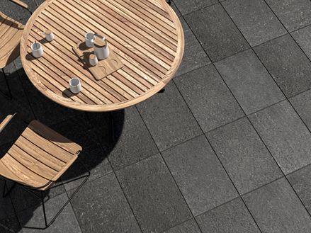 Terrasse avec dallage en basalte Takeda et meubles de jardin en bois