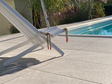 Chaise longur sur plage de piscine en dalles de grès cérame effet ardoise Canyon Pearl