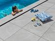 Une fillette se baigne dans la piscine aux margelles en grès cérame effet ardoise Alpine Grey