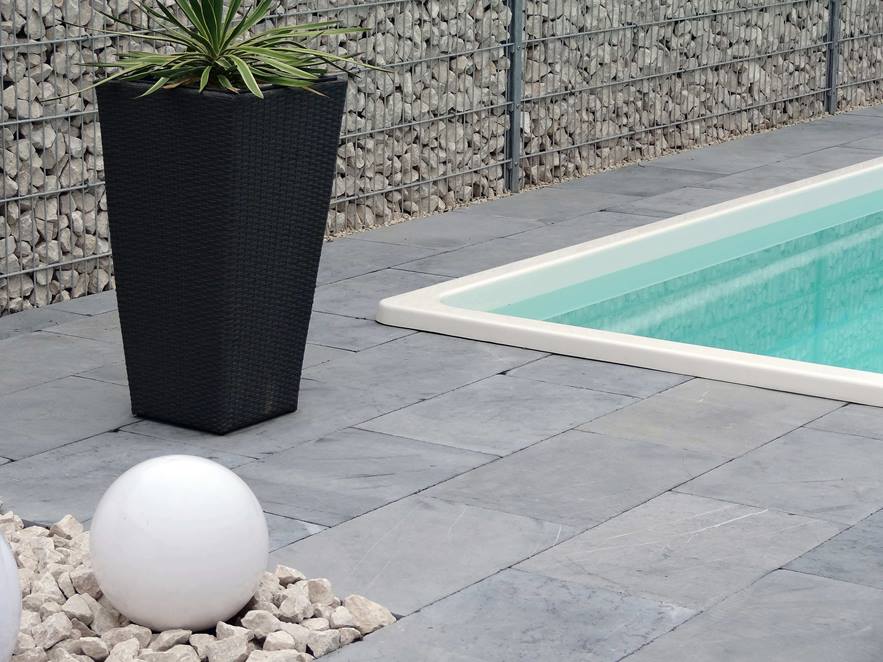 Bord de piscine avec palmier et dallage en pierre calcaire Blaustein Azur