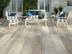Une terrasse au style maritime avec un salon de jardin et des dalles imitation bois clair au sol