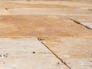 Le travertin  Gold vieilli a une surface très douce au toucher Gros plan sur les dalles de terrasse en travertin Gold