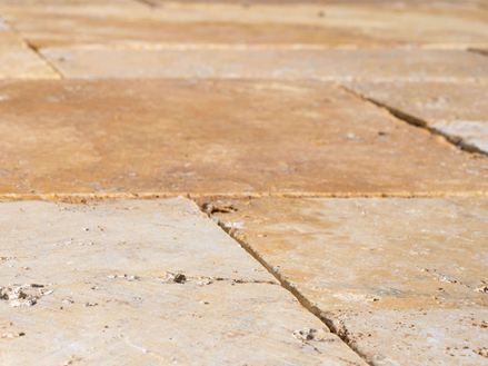 Gros plan sur les dalles de terrasse en travertin Gold