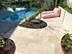Terrasse avec dallage en travertin Medium Select, piscine et sièges de jardin roses