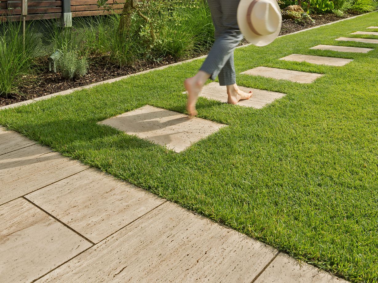 Une jeune femme marchant sur les dalles en travertin Natura