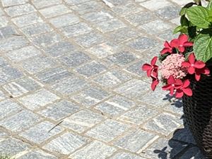 Galerie 1 : pavés en gneiss « Urban Grey Line » dans un cadre verdoyant agrémenté de fleurs