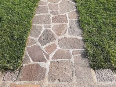 Les dalles polygonales en porphyre Terra entourée de gazon