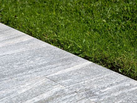 Les dalles en granite Urban Grey Line à côté d'une pelouse