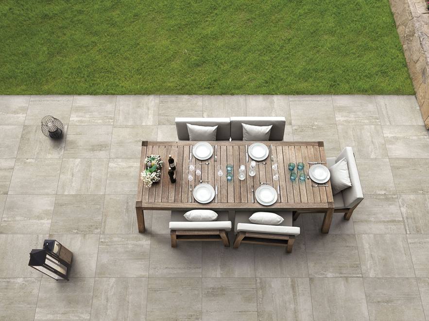  Une terrasse décorée du dallage à l'effet béton beige Concrete Sand et d'un salon de jardin