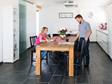 Un couple installé à la table de la cuisine dans laquelle est posée un carrelage en ardoise Black Rustic