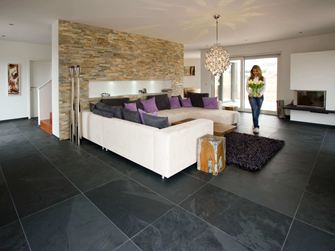 Chez un client : carrelage en ardoise Mustang, posé dans le salon, et une femme apportant des tulipes