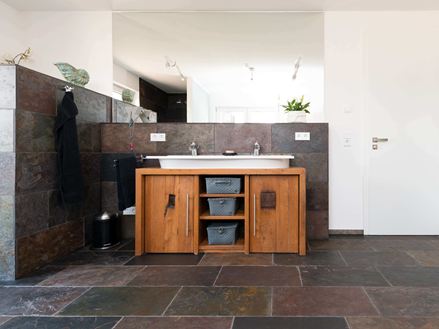 Le carrelage en ardoise Peacock dans une salle de bain en même temps rustique et moderne