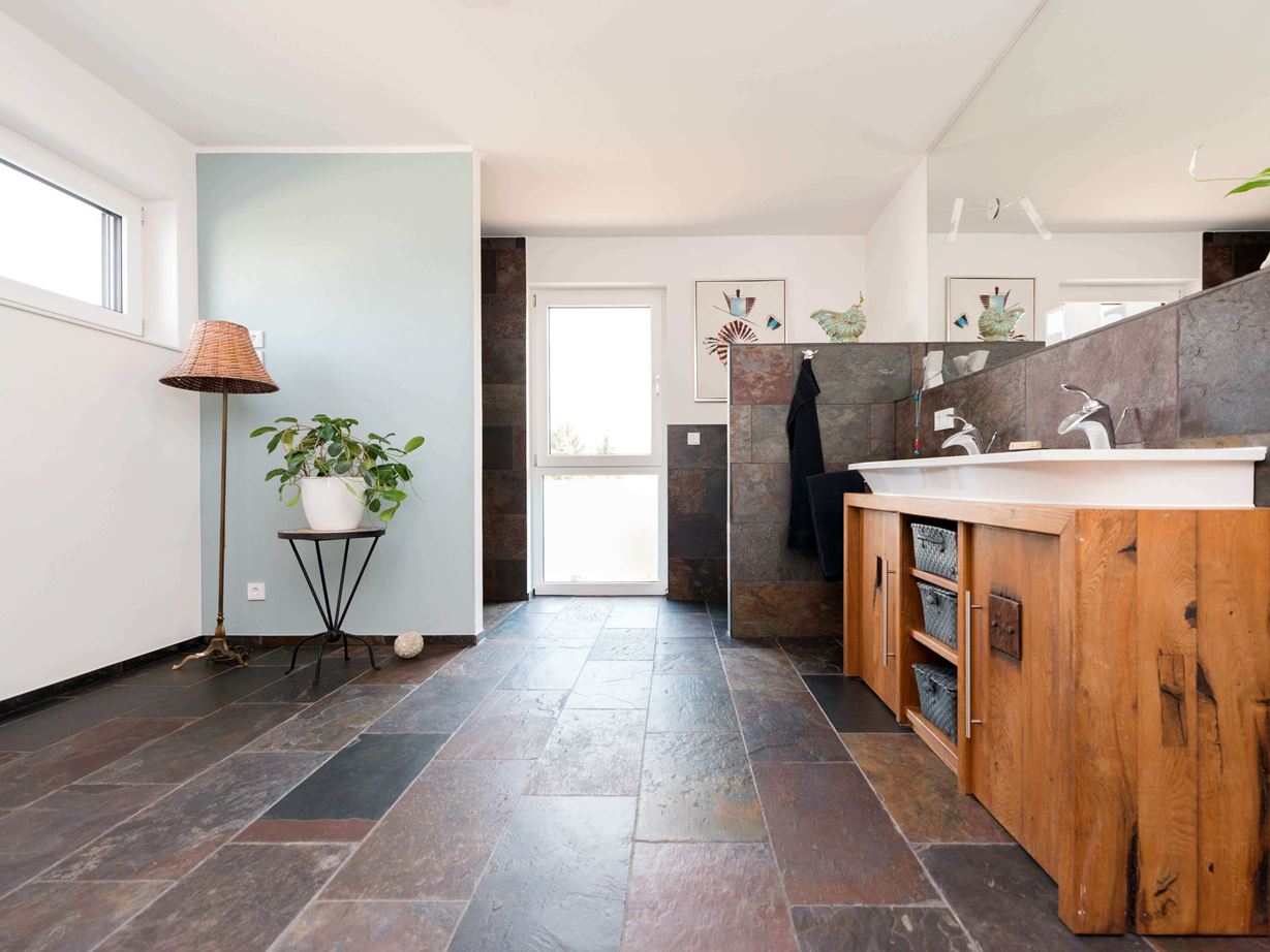 Salle de bains avec meubles en bois et carrelage en ardoise colorée