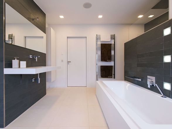 Salle de bains moderne avec carrelage en pierre calcaire clair comme revêtement de sol et ardoise foncée sur le mur.