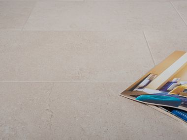 Le carrelage imitation pierre Sevilla Cream et un magazine