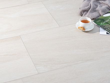 Le carrelage effet pierre Mountain Beige avec une tasse de café et une couverture