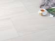 Le carrelage effet pierre Mountain Beige avec une tasse de café et une couverture