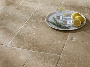 Vue de près sur le carrelage en travertin Classic Country et un plateau posé sur le sol