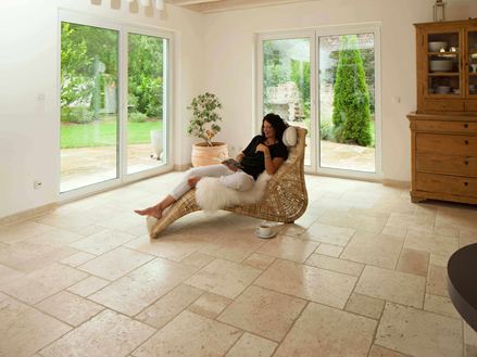 Femme allongée dans une chaise longue sur des carreaux de travertin clair