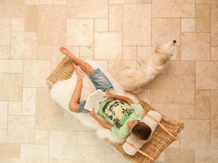 Garçon lit dans une chaise longue sur des carreaux de travertin clairs en opus romain