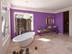 Salle de bain avec baignoire, carrelage en travertin Light et mur violet