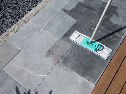 Balai à franges sur une terrasse en pierre calcaire