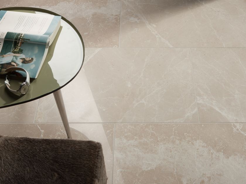 Une table ronde avec un livre et une montre sur le carrelage en marbre Burdur Cream