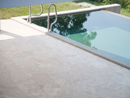 Piscine moderne avec travertin Medium Line à côté