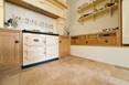 Cuisine rustique avec des carreaux de travertin de couleur beige-brun comme revêtement de sol
