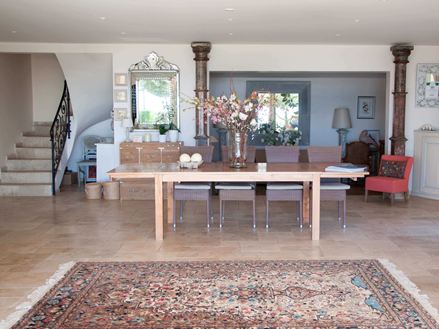 un tapis une table avec un bouquet de fleur gauche un escalier