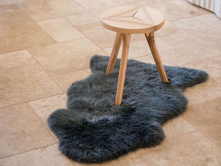 Travertin Medium-Fliesen mit dreibeinigem Holzhocker