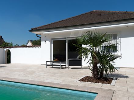 Terrasse en travertin méditerranéen avec piscine et palmiers