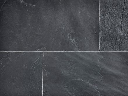 Gros plan sur des carrelages d'ardoise Black Rustic posées en anthracite avec des joints de couleur claire.