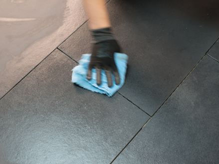 Hand entfernt überschüssiges Imprägniermittel mit einem Tuch