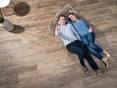 Couple couché sur des tuiles optiques en bois Indie Nova photographié de haut