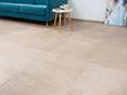 Carrelage en effet pierre calcaire avec divan turquoise et table d'appoint blanche