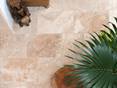 Aufnahme von verlegtem Travertin Rustic mit Pflanzen und Holzaccessoires aus der Vogelperspektive